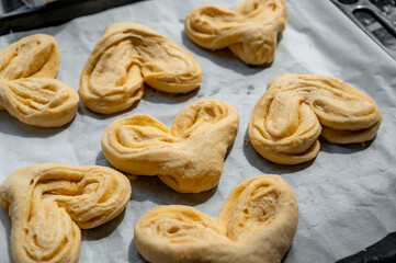 Raw buns on a baking tray with parchment paper