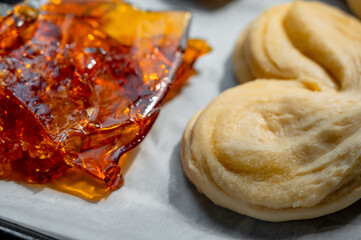 Raw buns on a baking tray with brown caramel sheet, high-sugar and carbohydrate food