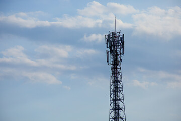 A metal cell phone tower mast for mobile telecommunication radio equipment against a blue sky