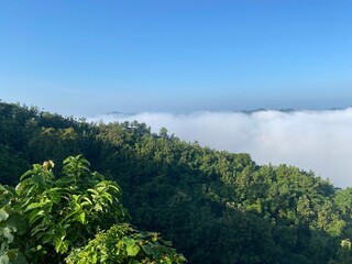 hills with beautiful clouds in the morning. Summer Mountain with green plants and clouds in the sky. wooden hut on Mountain. Texture of green tree forest view from above, Beautiful sunrise.