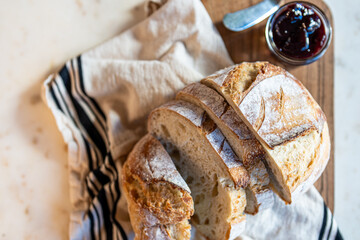 Bread, traditional sourdough, homemade sourdough bread cut into slices on a rustic wooden cutting board, and linen cloth. Healthy organic food. Concept of traditional leavened bread baking methods. 