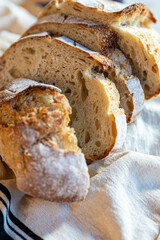 Bread, traditional sourdough, homemade sourdough bread cut into slices on a rustic wooden cutting board, and linen cloth. Healthy organic food. Concept of traditional leavened bread baking methods. 