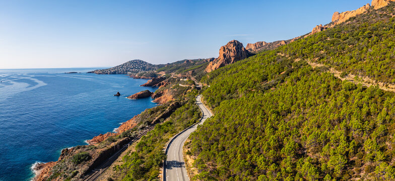 Aerial view of Esterel Mountains and winding coastal road above the blue Mediterranean Sea, French Riviera, France - Powered by Adobe