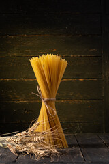 Golden Spaghetti. Dramatic Still Life on Black Backlit Background.