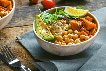 Bowl of chickpeas, salad, sweet potato, salad and avocado