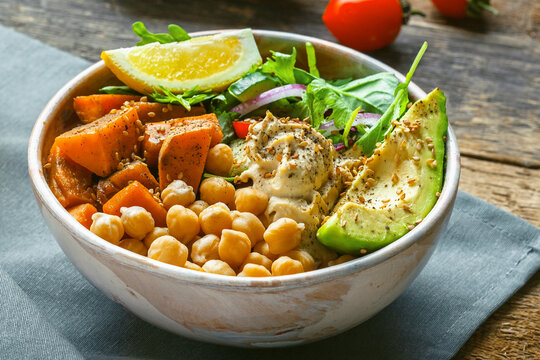 Bowl of chickpeas, salad, sweet potato, salad and avocado