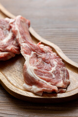 Raw Chops with Garlic and Spices on a Wooden Plate