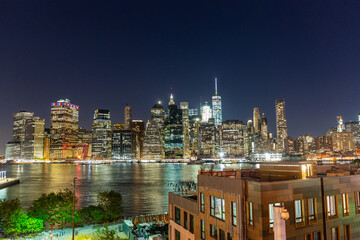Night view of the Manhattan skyline from the Brooklyn Promenade with the green piers of Brooklyn bridge park in the foreground 