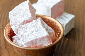 Assorted Turkish Delights in a Copper Bowl on a Wooden Table (Close-Up)
