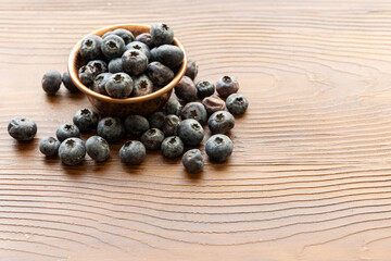 Close-Up of Wild Blueberries in a Copper Bowl on a Wooden Surface

