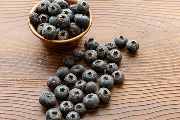Close-Up of Wild Blueberries in a Copper Bowl on a Wooden Surface
