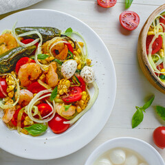 Mediterranean zucchini noodles with prawns, mozzarella, and colorful vegetables