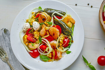Zucchini pasta with shrimp, mini mozzarella, corn, and grilled vegetables on a plate