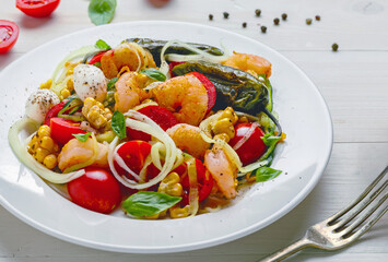 Mediterranean zucchini noodles with prawns, mozzarella, and colorful vegetables