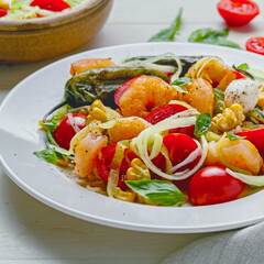 Zucchini pasta with shrimp, mini mozzarella, corn, and grilled vegetables on a plate