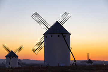 Campo de Criptana windmills silhouetted against vibrant sunset sky