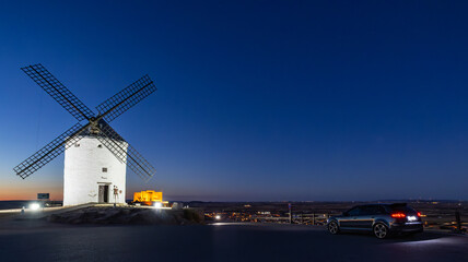 Consuegra windmill in twilight with modern car parking