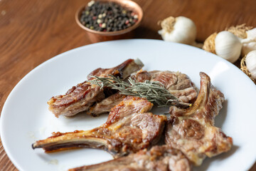 Garlic and Herb Crusted Chops on a White Plate on a Wooden Table
