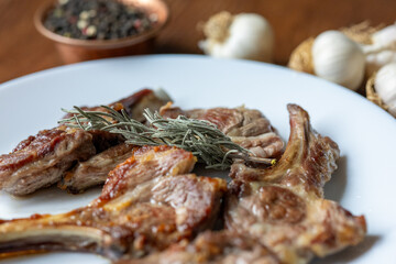 Garlic and Herb Crusted Chops on a White Plate on a Wooden Table
