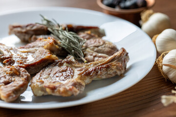 Garlic and Herb Crusted Chops on a White Plate on a Wooden Table
