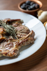 Garlic and Herb Crusted Chops on a White Plate on a Wooden Table
