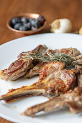Garlic and Herb Crusted Chops on a White Plate on a Wooden Table
