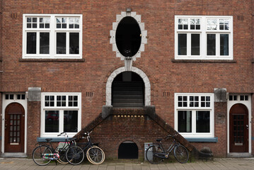 Unique architectural design with bicycles parked at the foot of an historic building Amsterdam Netherlands
