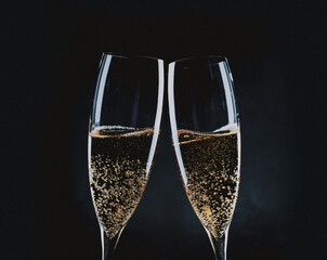 toasting with champagne glasses against holiday lights