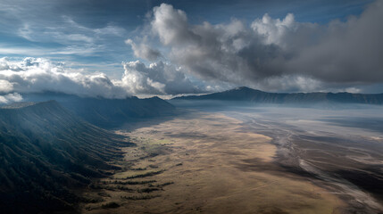 Obraz premium Aerial View of Indonesia's Volcanic Terrain: Sweeping Valley and Dramatic Clouds in a Picturesque Mountain Landscape for Scenic Nature Photography