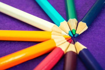 Naklejka premium Nine multicolored pencils on a purple felt background. Different colored pencils with space for text. Back to school. Art lessons.