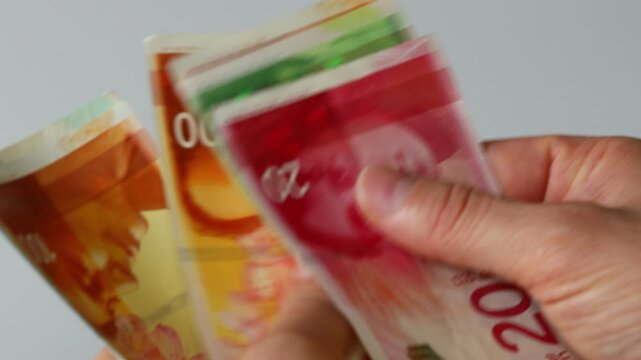 Israel money. Counting Israeli shekels in hand. Financial business concept. Close up