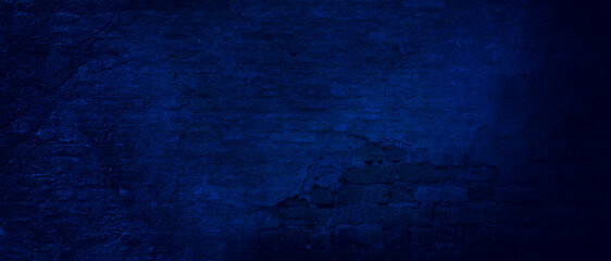 The texture of the brick old wall of many rows of bricks painted in blue color black . old dark blue brick wall of an old architecture building. brick wall texture. navy blue masonry of stone blocks 