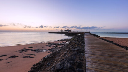 Wooden pier leading to a small island in the sea on the coast of Fuerteventura