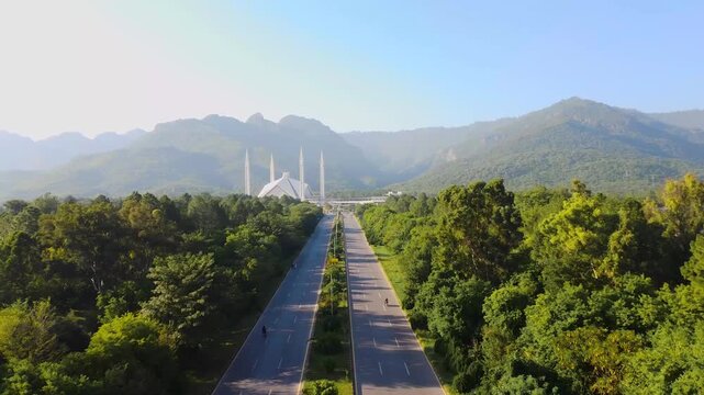 Long Aerial Shot Down Main Avenue Towards Faisal Mosque with Margalla Hills in the Background
