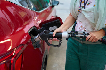Fototapeta premium Person refueling car at gas station with fuel pump oil and gas price crisis