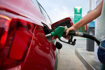 Person refueling red car with petrol at gas station oil and gas price crisis © alvaro