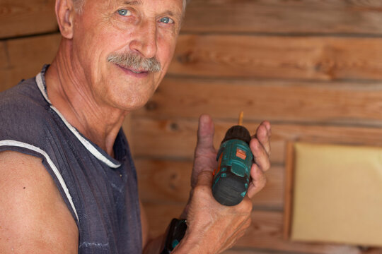 a male employee holds an electric screwdriver - Powered by Adobe