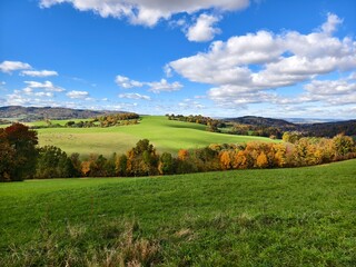 Autumn hilly landscape with fields and pastures