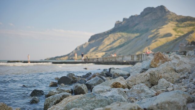 Rocky beach in Crimea overlooking the Black Sea with mountains in the background - Powered by Adobe