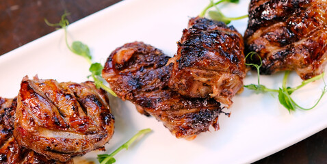 Grilled chicken liver on plate over dark stone background. Top view, flat lay. High quality photo