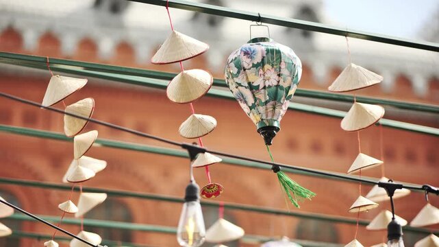 Traditional vietnamese conical hats and silk lanterns decorating outdoor market in Vietnam