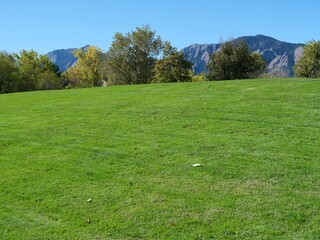 Green Lawn Hill and the Flatirons under Clear Blue Autumn Sky in Boulder, Colorado