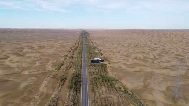 drone shot of a straight road through desert in xinjiang, china