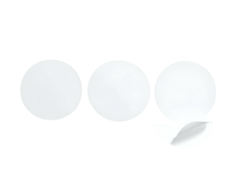 Three white circular stickers, one partially peeled, against a stark black background (1)