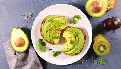 Avocado toast with sliced green avocado and spices on whole grain bread, served on a white plate on a dark gray background