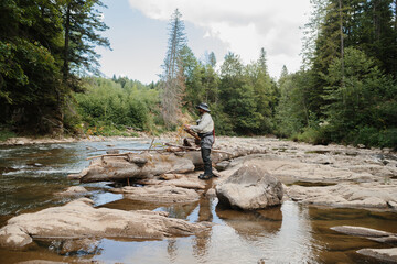 Fisherman preparing his fishing rod in a mountain river