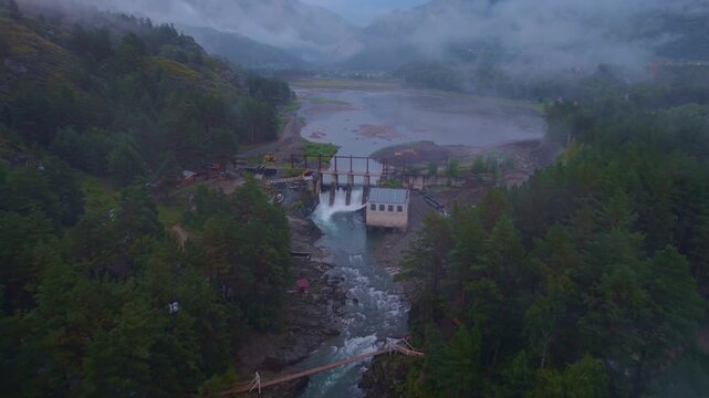 Chemal hydroelectric power plant with fog. Altai Siberia Russia, aerial top view.