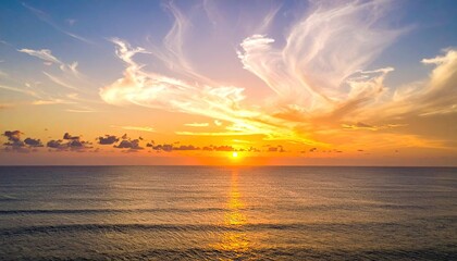Golden Ocean Sunset with Wispy Clouds and Rippling Water Reflecting the Sun