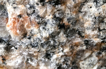 An extreme macro close-up photograph showcasing the intricate crystalline structure and rough texture of granite rock. 