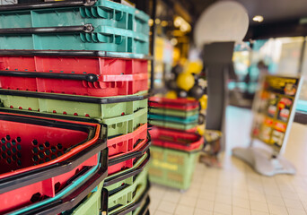 Fototapeta premium Colorful plastic shopping baskets stacked in a supermarket, retail store equipment symbolizing shopping, consumerism, retail industry and modern commerce background